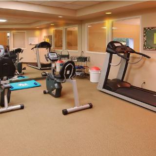 A well-equipped gym with various exercise machines including a treadmill and stationary bike.