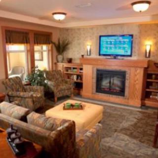 A cozy living room featuring a fireplace and television, surrounded by comfortable seating and modern decor.
