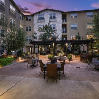 A beautifully lit apartment courtyard with outdoor seating in the evening.