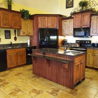 A spacious kitchen featuring wooden cabinets, a central island, and modern appliances.
