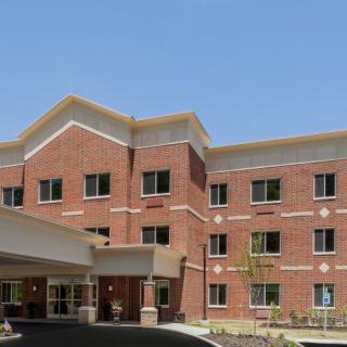 A brick hospital building with multiple windows and a main entrance.