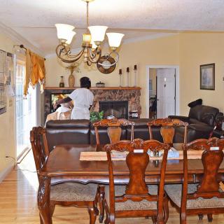 A cozy interior featuring a dining and living area with a wooden dining set and a chandelier.
