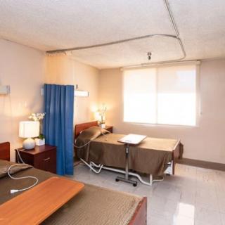 A hospital room with two beds and medical equipment.