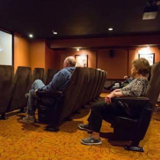 A cozy home theater setup with two individuals enjoying a movie.