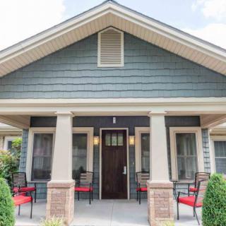 A charming bungalow with a covered porch and inviting seating area.