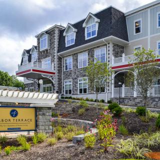 A residential building with a stone facade, surrounded by landscaped gardens.