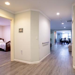 A modern home interior featuring a hallway leading to a bedroom and living area.