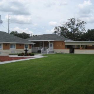 A suburban house with a well-maintained lawn and a clear sky.