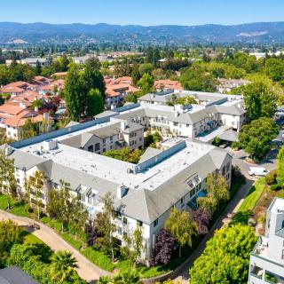 Aerial view of a residential building complex surrounded by trees and greenery.