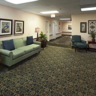 A cozy lobby area featuring a sofa, chairs, and decorative elements like plants and artwork.
