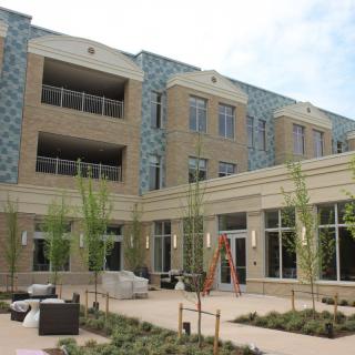 A modern residential building with an outdoor seating area.