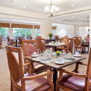 An elegantly set dining room with neatly arranged tables and chairs, ready for guests.