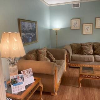 A cozy living room with comfortable sofas, a lamp, and artwork on the walls.