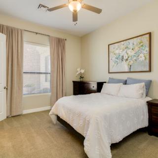 A cozy and well-lit bedroom featuring a double bed, minimalist decor, and soft natural hues.