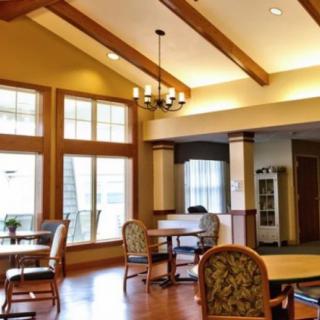 A cozy dining area with wooden beams and large windows.