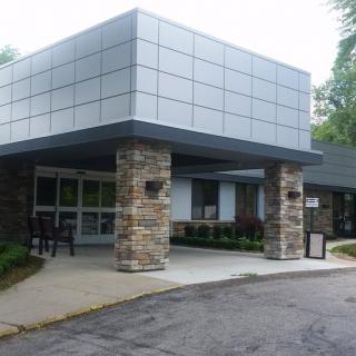 A modern commercial building entrance with stone pillars and a flat roof.