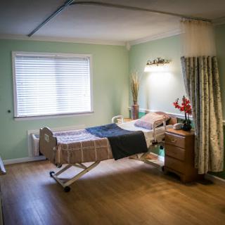 A tranquil hospital room designed for patient comfort, featuring a bed, natural light, and soft decor.