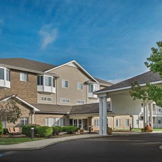 A residential housing complex with landscaped surroundings under a clear blue sky.