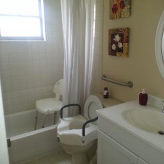 A small bathroom with a toilet, sink, and shower with a curtain.