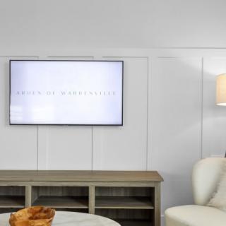A cozy living room with a wall-mounted television and stylish furniture.