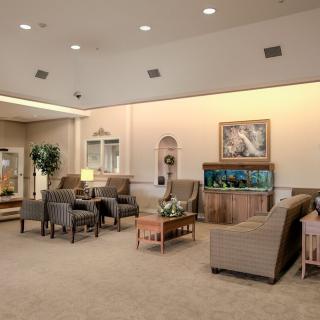 A comfortable waiting area with armchairs, a fish tank, and elegant interior decor.
