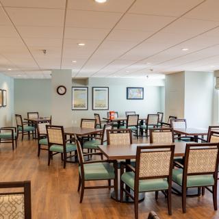 An empty dining room with neatly arranged tables and chairs.