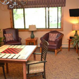 A cozy living room with leather chairs and a decorative table near a large window.