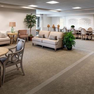 A spacious and elegantly furnished waiting area with comfortable seating and decorative plants.