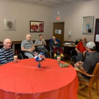 Residents of a senior community engage in a group activity in a cozy indoor setting.