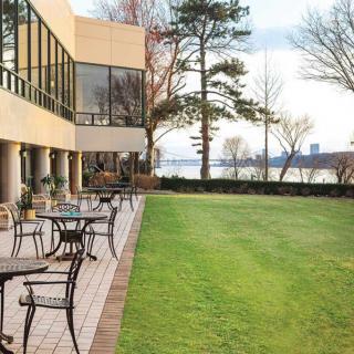 A scenic outdoor patio with tables and chairs overlooking a river.
