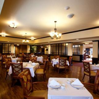 A cozy restaurant dining area with elegantly set tables and warm lighting.
