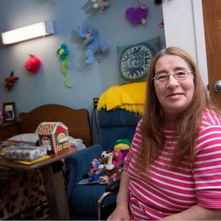A warm and inviting room where a smiling person sits comfortably, surrounded by colorful decorations.