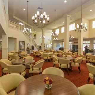 A spacious dining area with elegant chandeliers and comfortable seating arrangements.