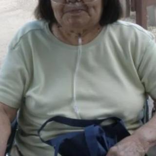 An elderly woman in a wheelchair with an oxygen tube.
