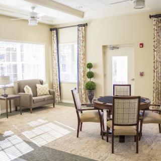 A cozy and inviting living space with natural light, featuring a seating area and a dining table.