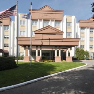 A hotel entrance with flags and landscaped surroundings.