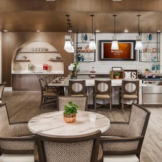 A modern and stylish kitchen area with seating and decorative lighting.