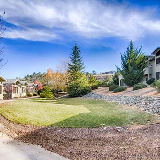 A scenic view of a quiet residential neighborhood with lush greenery and clear blue skies.