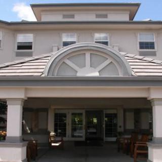 An entrance to a multi-story building with large windows and a covered entryway.