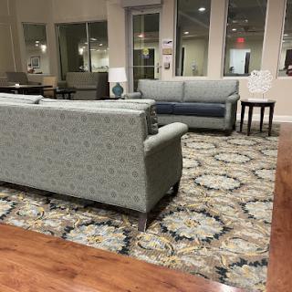 A cozy lounge area featuring patterned sofas and a decorative rug.