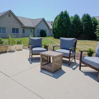 A sunny backyard patio with comfortable seating and a small table.
