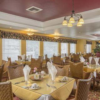 An elegant restaurant dining area with neatly arranged tables and chairs, featuring upscale decor and ambient lighting.