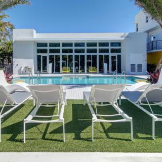 A modern outdoor pool area with lounge chairs and a clear blue sky.