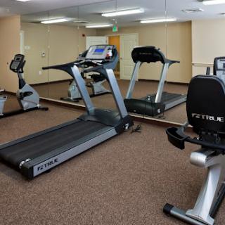 A well-equipped indoor gym featuring a treadmill and stationary bikes.