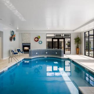 A well-lit indoor swimming pool with modern decor and large windows.