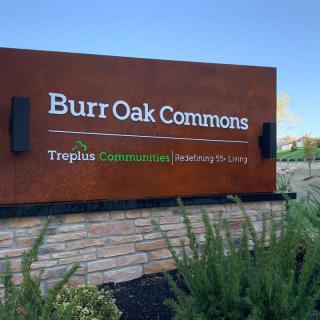 Sign for Burr Oak Commons by Treplus Communities, surrounded by neatly maintained landscaping.
