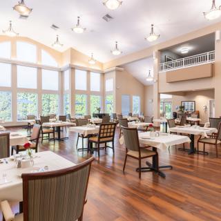 Spacious dining area with large windows and elegantly arranged tables.