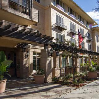 The exterior of a hotel with a welcoming entrance and decorative plants.