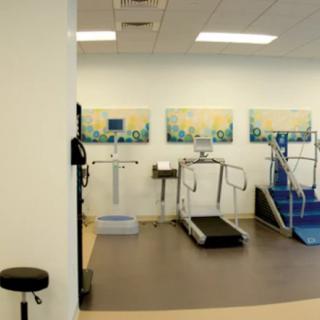 A physical therapy room equipped with a treadmill and other rehabilitation tools.