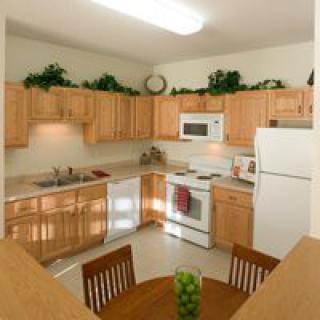 A cozy kitchen with wooden cabinets and a small dining area.